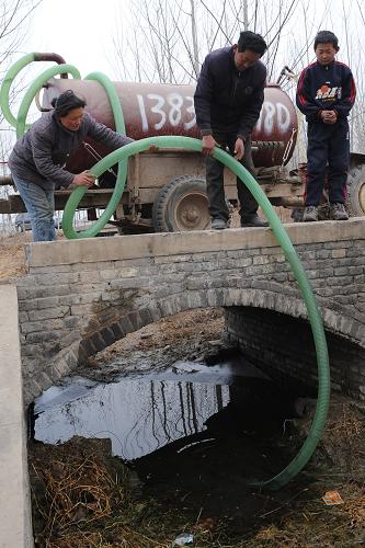 河南省尉氏縣門樓任鄉(xiāng)的蔡站海(中)一家在河邊抽水抗旱(2月3日攝)。新華社記者 趙鵬 攝