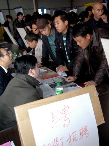 2月7日,在西安市丈八路人力資源市場“春風行動專場招聘會”現場,求職農民工與招聘人員交談。新華社記者 丁海濤 攝