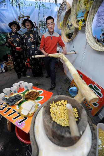 3月21日,工作人員在一農(nóng)家游展臺上演示磨制豆?jié){的過程。新華社記者 韓瑜慶 攝