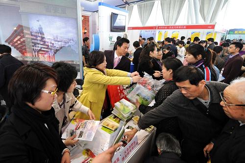 3月21日,上海旅游展位的工作人員在向參觀者發(fā)放旅游宣傳資料。新華社記者 孫參 攝