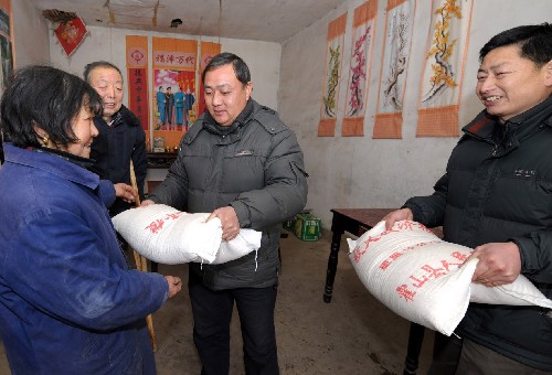 霍山縣朱佛庵鎮(zhèn)的干部為因災(zāi)倒房戶陳朝霞(左)家送上兩袋大米(1月30日攝)。位于大別山區(qū)的安徽霍山縣自1月12日起連續(xù)普降中到大雪,山區(qū)部分鄉(xiāng)鎮(zhèn)遭遇暴雪。持續(xù)降雪給該縣人民的生產(chǎn)、生活造成嚴(yán)重影響。當(dāng)?shù)卣扇〕皟?、就地加工、為困難戶送糧上門、平價供應(yīng)四項措施,積極解決雪災(zāi)后出現(xiàn)的吃糧難等問題。 新華社記者 陳曄華 攝