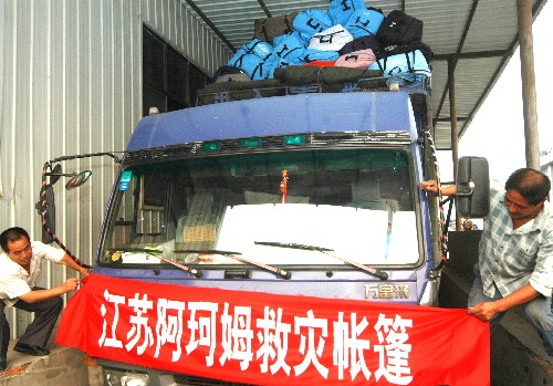 6月12日,在阿珂姆野營用品有限公司生產(chǎn)區(qū),工人們將救災(zāi)帳篷裝車準備運往四川災(zāi)區(qū)。 新華社發(fā)(濮良平 攝)
