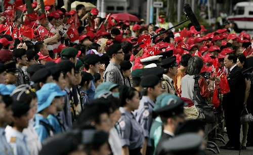 7月1日,香港特區(qū)行政長(zhǎng)官曾蔭權(quán)(右)與市民、游客握手致意。當(dāng)日,為慶祝香港回歸祖國(guó)11周年,香港特區(qū)政府在香港金紫荊廣場(chǎng)舉行隆重的升旗儀式。 新華社記者 周磊 攝