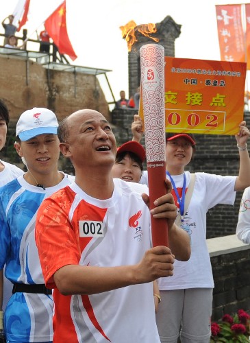 7月30日,火炬手聶瑞平仰望圣火。當(dāng)日,北京奧運(yùn)圣火在河北省秦皇島市傳遞。 新華社記者楊世堯攝
