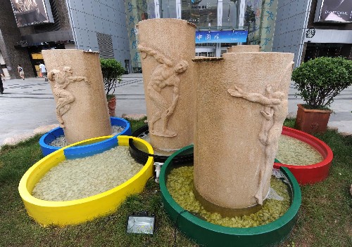 青島市區(qū)一家商廈前的奧運(yùn)主題雕塑(7月28日攝)。 新華社記者 宋振平 攝