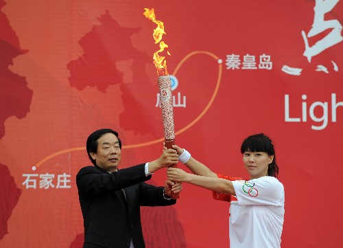 7月31日,第一棒火炬手錢紅(右)從中共河北省委常委、唐山市委書記趙勇手中接過火炬。當日,北京奧運圣火在河北省唐山市傳遞。 新華社記者鞏志宏攝