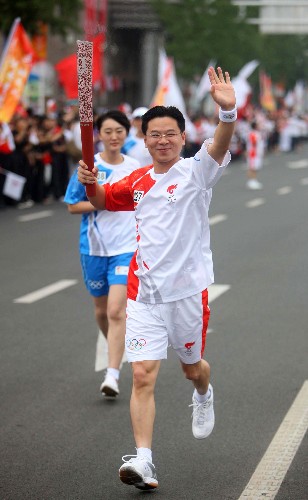 7月31日,火炬手蔡建平手持火炬進行傳遞。當日,北京奧運圣火在河北省唐山市傳遞。 新華社記者邢廣利攝