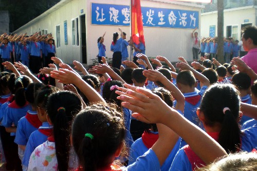 9月1日,四川省雅安市雨城區(qū)興賢小學(xué)學(xué)生參加開(kāi)學(xué)典禮。當(dāng)日,四川地震中被毀壞的部分中、小學(xué),在臨時(shí)板房校區(qū)舉行了新學(xué)期開(kāi)學(xué)典禮。新華社記者 陳?ài)啤z