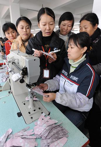 12月11日,剛從廣東東莞打工回鄉(xiāng)的江西宜豐縣城東鄉(xiāng)婦女劉紅梅(前右一)在一家鞋業(yè)公司接受免費(fèi)技能培訓(xùn)。新華社記者 宋振平 攝