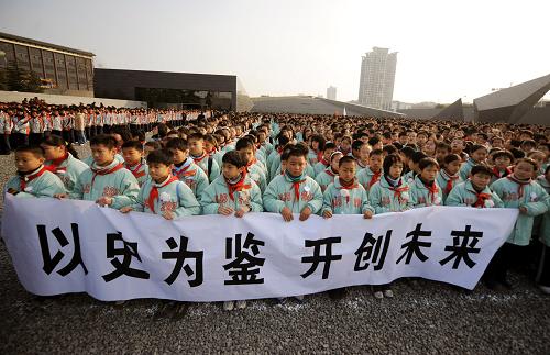12月13日,南京市小學(xué)生代表手持“以史為鑒 開創(chuàng)未來”的橫幅參加悼念儀式。新華社記者 韓瑜慶 攝