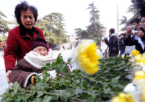 12月13日,南京大屠殺幸存者、95歲的吳秀蘭老人為南京大屠殺遇難同胞敬獻鮮花。新華社記者 韓瑜慶 攝