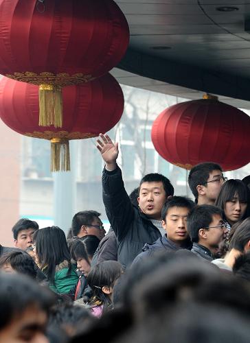 2月2日,在太原人才大市場(chǎng),一名在門前等候的求職者招呼身后的同伴。新華社記者 燕雁 攝