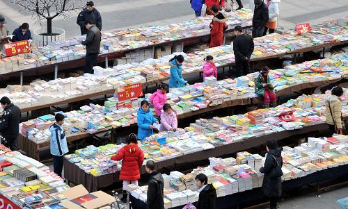 1月30日,市民在北京望京一家購(gòu)物廣場(chǎng)書攤上購(gòu)買圖書。新華社發(fā)(樊甲山 攝)