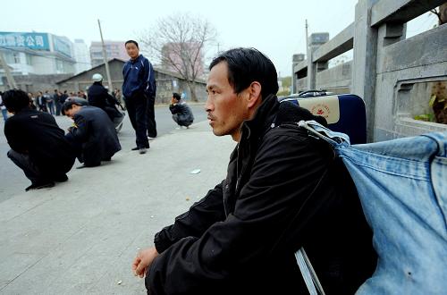 2月10日,一位來自河南的農(nóng)民工在福州一路邊用工市場等待招工。他抵達(dá)福州7天了,由于對當(dāng)?shù)厍闆r不了解,每天都來火車站附近的這一路邊用工市場尋找工作。新華社記者 張國俊 攝