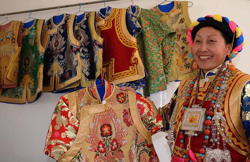 這是德欽縣奔子欄鎮(zhèn)奔子欄村的藏族婦女卓瑪拉姆在展示她制作的民族服裝。她家年收入超過5萬元(2月6日攝)。新華社記者 藺以光 攝