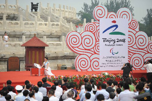 8月28日,北京殘奧會圣火采集暨火炬接力啟動儀式在北京天壇祈年殿南廣場舉行。這是圣火采集使者姜馨田引燃引火棒。 新華社記者楊光攝