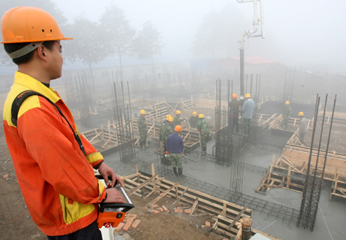 11月23日,建筑工人在蘇州援建的綿竹市齊天鎮(zhèn)中心小學(xué)建設(shè)工地澆筑水泥。新華社記者 戚振林 攝