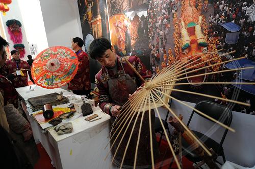 2月17日,油紙傘傳統(tǒng)制作工藝第六代傳人許學(xué)明(右一)現(xiàn)場(chǎng)制作油紙傘。 新華社記者 金良快攝