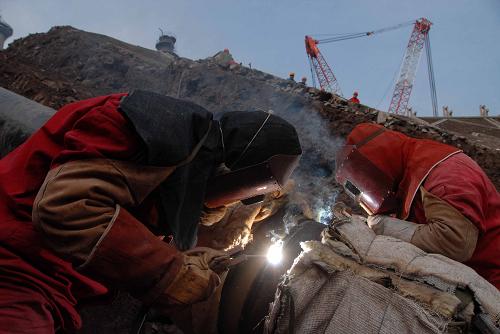 建設(shè)者在川氣東送工程四川達(dá)州宣漢縣工地上打磨管道準(zhǔn)備進(jìn)行焊接(攝于2008年12月7日)。我國橫貫東西的又一條能源大動脈——川氣東送工程經(jīng)過萬余名參建人員近兩年建設(shè),影響管道主體貫通的天塹被全部攻克,工程建設(shè)取得重大進(jìn)展。截至2009年2月10日,川氣東送管道已完成組焊近1900公里,占需組焊總量的95%;5條穿越長江的隧道掘進(jìn)已全部結(jié)束;72條山體隧道累計掘進(jìn)90多公里,僅剩2條隧道尚未貫通。新華社發(fā)(胡慶明 攝)