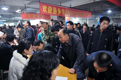 2月20日,重慶農(nóng)民工在市內(nèi)最大的南紀(jì)門勞務(wù)市場(chǎng)與招聘人員交流。新華社記者 楊磊 攝