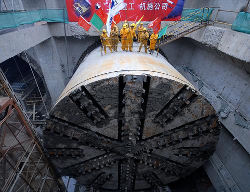 3月1日,建筑工人站在盾構(gòu)上慶祝人民路越江隧道全線貫通。 新華社發(fā)
