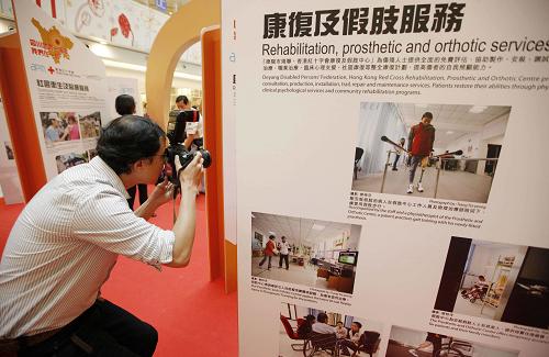 5月11日,一名記者在拍攝參展圖片。當(dāng)日,在四川地震一周年即將來臨之際,“四川地震一周年 我們?cè)谝黄?#8221;圖片展在香港揭幕。展覽由香港紅十字會(huì)與曾多次派出攝影師隨紅十字會(huì)人員前往四川地震災(zāi)區(qū)的香港攝影記者協(xié)會(huì)聯(lián)合舉辦,數(shù)十幅由香港攝影記者拍攝的照片記錄下香港紅十字會(huì)在災(zāi)區(qū)的工作情況和災(zāi)區(qū)恢復(fù)重建的歷程。 新華社記者 周磊 攝