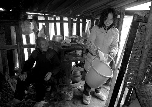 2009年2月8日,好心的鄰居為獨(dú)自居住在棚屋的劉慧珍老人送水。