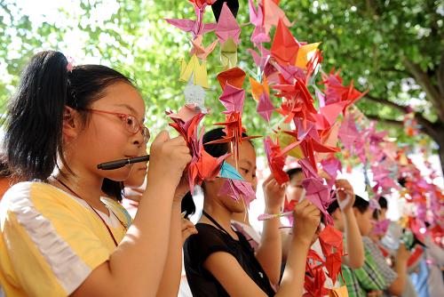5月11日,南昌市西湖區(qū)松柏小學(xué)學(xué)生在千紙鶴上寫祝福語。當(dāng)日,南昌市小學(xué)生以折千紙鶴、觀圖片展、學(xué)習(xí)地震急救知識(shí)及參加逃生演習(xí)等活動(dòng)祭汶川地震一周年。 新華社發(fā)(周科 攝)