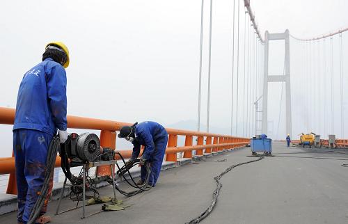 6月4日,施工人員在西堠門(mén)大橋上進(jìn)行防銹處理。新華社記者 徐昱 攝