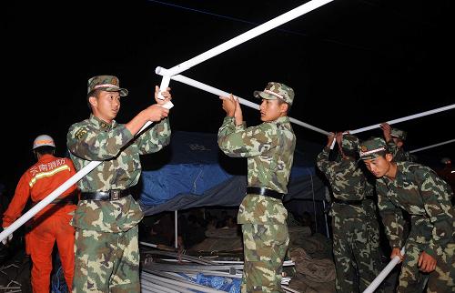 7月10日凌晨,武警官兵在云南省楚雄彝族自治州姚安縣官屯鄉(xiāng)官屯村為震區(qū)群眾搭建帳篷。新華社記者 藺以光 攝