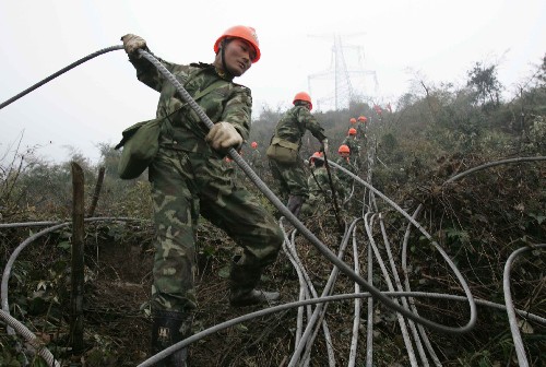武警水電官兵作風(fēng)頑強技術(shù)精 電力搶修建奇功 新華社照片,郴州(湖南),2008年2月18日 武警水電官兵作風(fēng)頑強技術(shù)精 電力搶修建奇功 2月18日,武警水電二總隊官兵在清理因災(zāi)損毀的高壓線路。 在江西撫州搶險救災(zāi)中做出突出貢獻的武警水電二總隊官兵,于2月13日千里馳援湖南郴州,在西電東送500千伏超高壓輸變電線路搶修重建中,承擔(dān)起施工條件最惡劣的36基倒塔的作業(yè)任務(wù),戰(zhàn)線全長40多公里,跨高速公路,越高山峻嶺。水電官兵發(fā)揮專業(yè)技術(shù)優(yōu)勢和英勇頑強的戰(zhàn)斗作風(fēng),同時在17個作業(yè)面上展開工作,截至發(fā)稿時,已成功拆除10基鐵塔。 新華社記者 王建民 攝