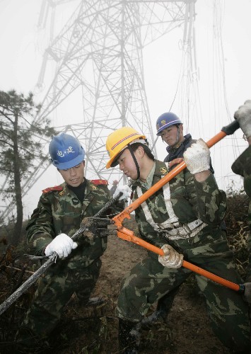2月18日,武警水電二總隊(duì)官兵在剪除受損高壓線路。