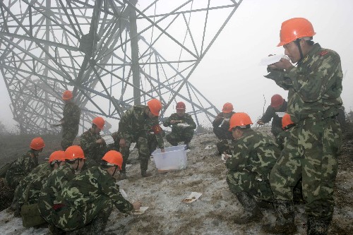 2月18日,武警水電二總隊(duì)官兵在施工現(xiàn)場(chǎng)吃午餐。 在江西撫州搶險(xiǎn)救災(zāi)中做出突出貢獻(xiàn)的武警水電二總隊(duì)官兵,于2月13日千里馳援湖南郴州,在西電東送500千伏超高壓輸變電線路搶修重建中,承擔(dān)起施工條件最惡劣的36基倒塔的作業(yè)任務(wù),戰(zhàn)線全長(zhǎng)40多公里,跨高速公路,越高山峻嶺。水電官兵發(fā)揮專業(yè)技術(shù)優(yōu)勢(shì)和英勇頑強(qiáng)的戰(zhàn)斗作風(fēng),同時(shí)在17個(gè)作業(yè)面上展開(kāi)工作,截至發(fā)稿時(shí),已成功拆除10基鐵塔。 新華社記者 王建民 攝