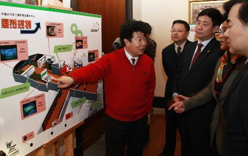 2月21日,一名工作人員(左一)正在向來賓介紹展示中心的布局。