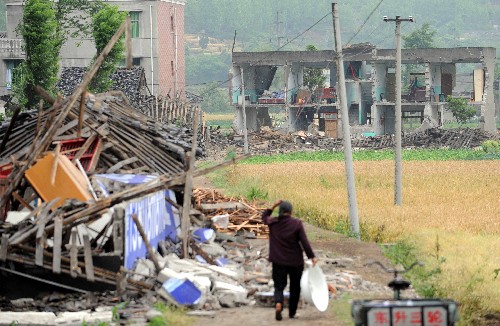 5月13日,北川縣城外公路兩旁到處是被損毀的建筑。地震造成四川北川縣老縣城80%、新縣城60%以上建筑垮塌,地震引發(fā)的山體滑坡讓縣城幾乎成為一片廢墟。 新華社記者楊磊攝