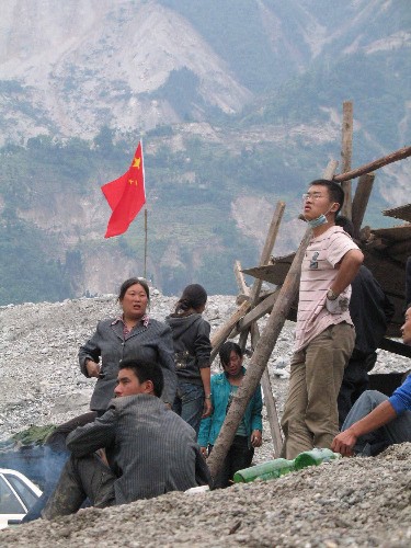 5月14日,當(dāng)?shù)匾恍?zāi)民在臨時(shí)搭建的簡(jiǎn)易房前。 汶川縣映秀鎮(zhèn)是汶川地震震中地區(qū)受災(zāi)最嚴(yán)重的地方之一。 新華社記者 侯大偉 攝