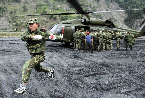醫(yī)療救護隊進入汶川地震災 5月14日,解放軍某部醫(yī)療隊抵達汶川縣映秀鎮(zhèn),救護隊員隨即趕往傷員集中地。當日,解放軍某部醫(yī)療隊乘坐直升機進入汶川、茂縣等災區(qū)。 新華社記者陳凱攝