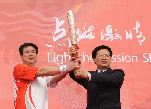 5月25日,江蘇省委副書記王國(guó)生(右)在起跑儀式上將火炬交給第一棒火炬手孫志安。當(dāng)日,北京奧運(yùn)會(huì)圣火在江蘇蘇州傳遞。 新華社記者孫參攝