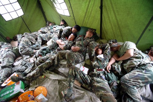 5月31日,水電官兵們?cè)诔冯x前進(jìn)行短暫的休息。 當(dāng)日,第一批武警水電官兵已乘直升機(jī)開(kāi)始從唐家山堰塞湖撤出,31日預(yù)計(jì)撤出350名左右官兵。據(jù)唐家山堰塞湖搶險(xiǎn)指揮部介紹,經(jīng)過(guò)緊張施工,截至31日7時(shí),已累計(jì)完成開(kāi)挖土石方12.35萬(wàn)方,大壩進(jìn)口高程降至741米,出口高程降至739米。 新華社記者李剛攝