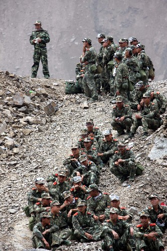 5月31日,水電官兵們等待撤離。 當(dāng)日,第一批武警水電官兵已乘直升機(jī)開(kāi)始從唐家山堰塞湖撤出,31日預(yù)計(jì)撤出350名左右官兵。據(jù)唐家山堰塞湖搶險(xiǎn)指揮部介紹,經(jīng)過(guò)緊張施工,截至31日7時(shí),已累計(jì)完成開(kāi)挖土石方12.35萬(wàn)方,大壩進(jìn)口高程降至741米,出口高程降至739米。 新華社記者李剛攝