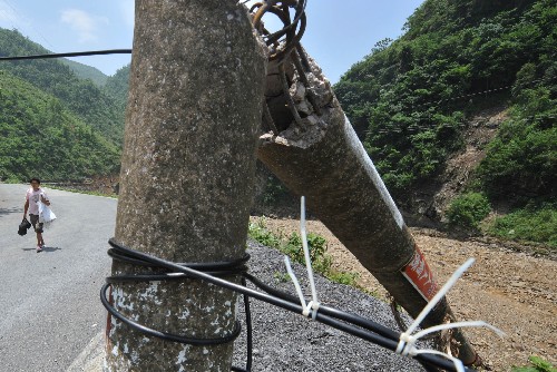 5月31日,一位村民從被洪水沖毀的電力、通訊設(shè)施旁走過。 受連日強降雨影響,貴州省的西部和南部遭受特大洪水與泥石流襲擊,損失嚴(yán)重。目前,各級政府已調(diào)集2萬余人的搶險隊伍有序展開搶險救災(zāi)工作。 新華社記者楊俊江攝