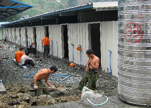 四川已建成近170萬套過渡安置房 新華社照片,映秀,2008年7月12日 四川已建成近170萬套過渡安置房 7月12日,幾名建筑工人在四川映秀鎮(zhèn)建造板房。據(jù)四川省政府抗震救災(zāi)新聞發(fā)布會消息,截至7月11日,四川已建成過渡安置房169.98萬套,其中農(nóng)民自建125.02萬套,省外援建活動板房43.08萬套,政府統(tǒng)建及社會捐建1.88萬套。根據(jù)國務(wù)院的有關(guān)決定精神,四川省計劃在8月12日前全部解決地震災(zāi)區(qū)受災(zāi)群眾過渡安置問題。 新華社記者海明威攝