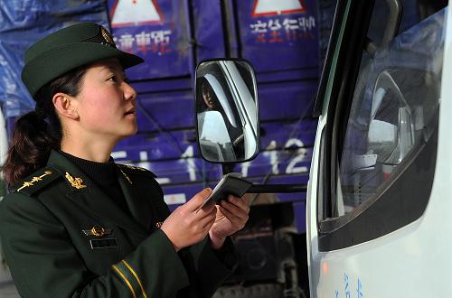 云南木康公安邊防檢查站的工作人員正在檢查貨車駕駛員的證件(12月24日攝)。