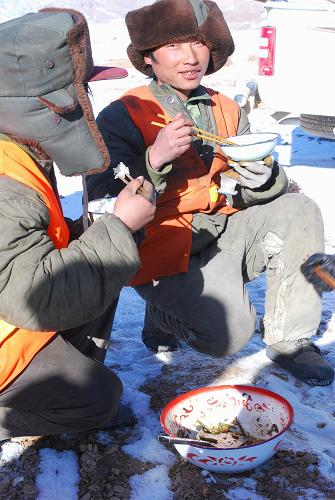 青藏鐵路:熱飯送到工地上 12月24日,工人在海拔3200米的連湖工地午餐。青藏鐵路西格(西寧—格爾木)二線工程穿越一望無(wú)際、渺無(wú)人煙的古老荒原,這里高寒缺氧,冬季更是風(fēng)雪迷漫,滴水成冰,氣溫低達(dá)零下30攝氏度。施工單位克服重重困難,創(chuàng)造條件為工地送去熱菜、熱飯,工人們告別了過(guò)去的“冰碴飯”、“凍饅頭”,極端氣溫下,建設(shè)工地洋溢著“以人為本”的濃濃暖意。 新華社記者文貽煒攝