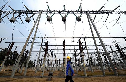 1月12日,一名電力工人從重新恢復(fù)的城前嶺變電站間穿過。