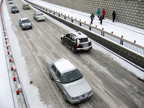 2月13日在吉林市松江西路上拍攝的車輛和行人。 受貝加爾湖較強冷空氣影響,從2月12日夜間開始,吉林省迎來一場罕見的雨雪天氣。據(jù)從12日20時到13日8時的統(tǒng)計,吉林省共有18個縣市出現(xiàn)暴雪天氣。吉林省氣象臺13日5時發(fā)布暴雪紅色預警信號、道路結冰紅色預警信號,提醒相關部門及時清雪,居民出行時要注意交通安全。 新華社發(fā)(朱萬昌攝)