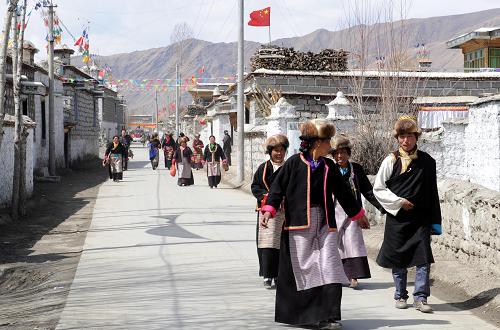 克松村村民走在寬敞的水泥路上(3月23日攝)。