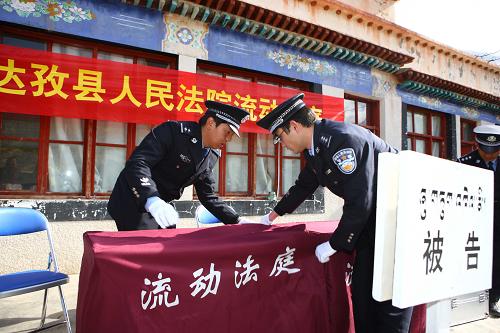 3月26日,兩名干警在“流動法庭”開庭前布置現(xiàn)場。