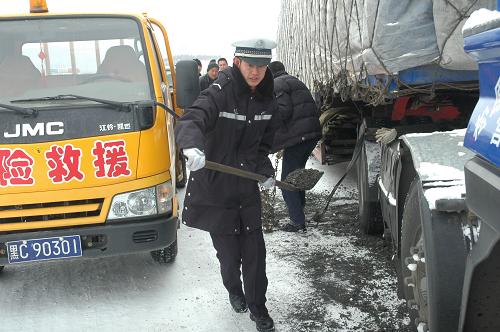 3月27日,在301國道牡丹江市東寧段,搶險救援人員進行防滑作業(yè),保障行車安全。