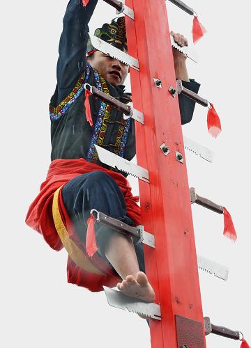 3月27日,畬族男子在歌會上進(jìn)行民俗表演——上刀山。